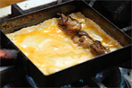 たっぷりの油をフライパンに注ぎ強火で熱してから卵を入れ、カキの甘辛煮を芯にするように置き、巻いていきます。